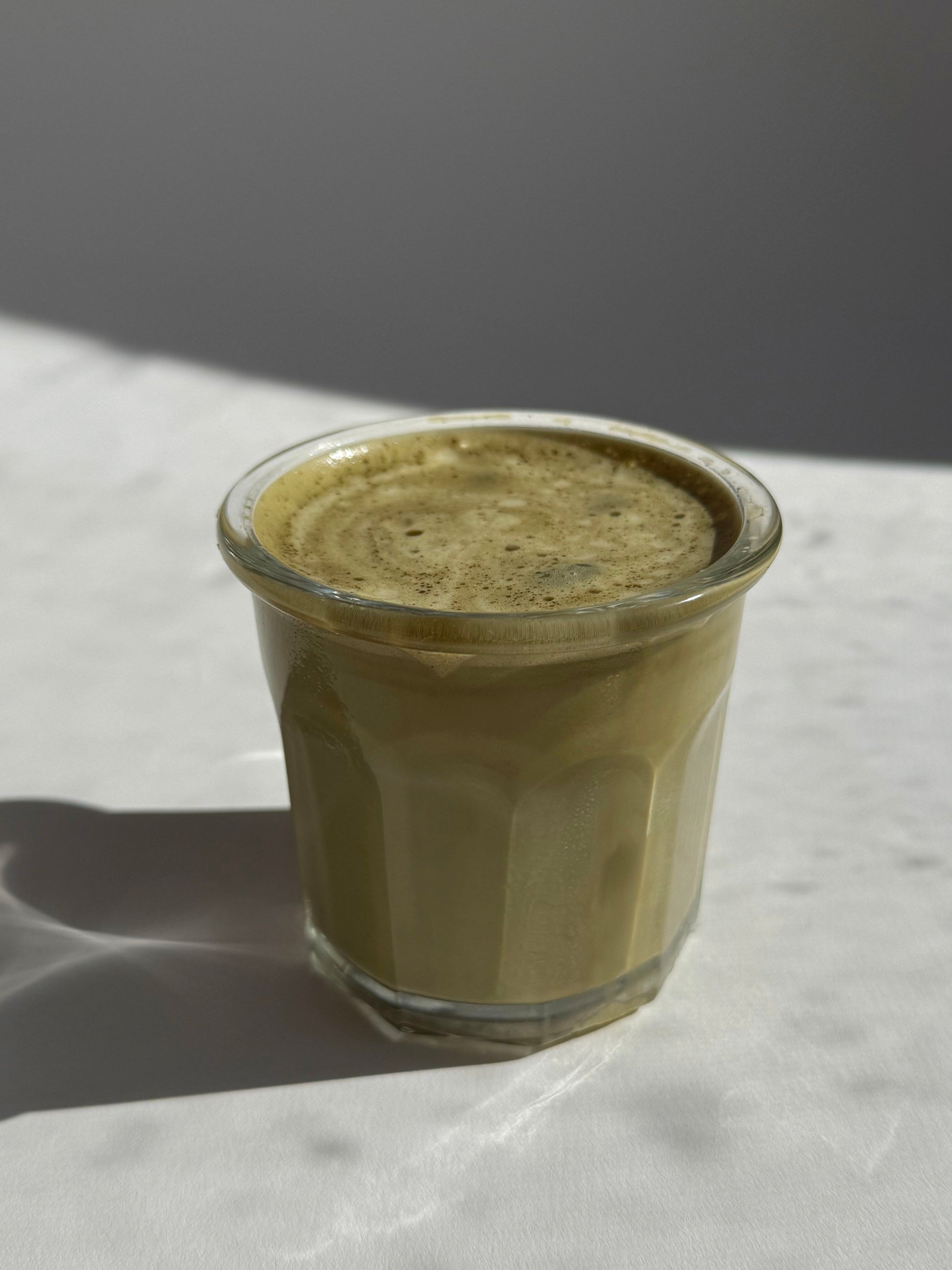 Glass in the sun with warm brown hojicha latte