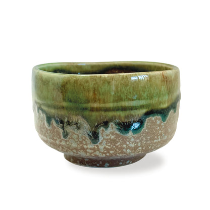 Green matcha whisking ceramic bowl with speckled pattern on a white background