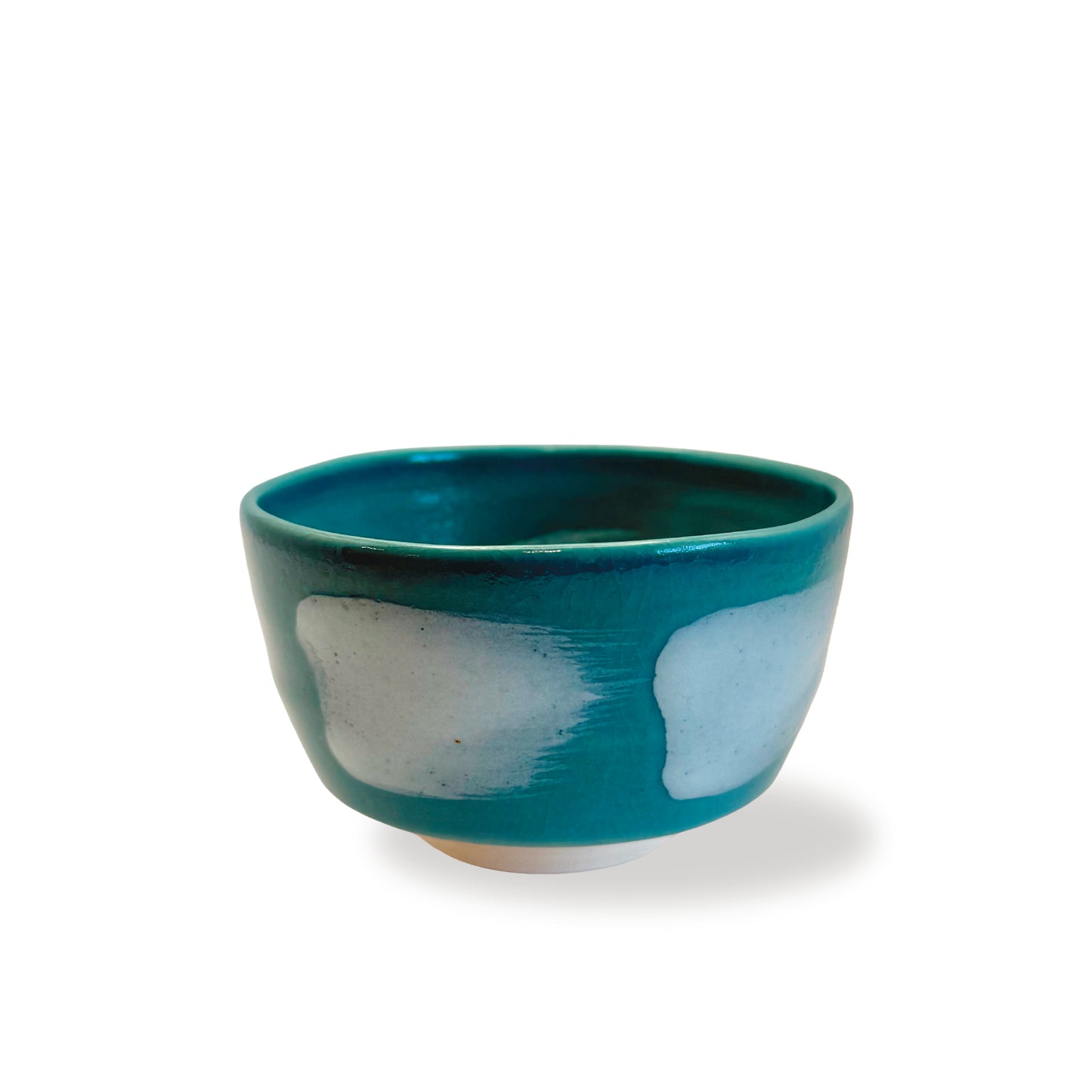 Blue ceramic bowl with white brushstrokes placed on a white background