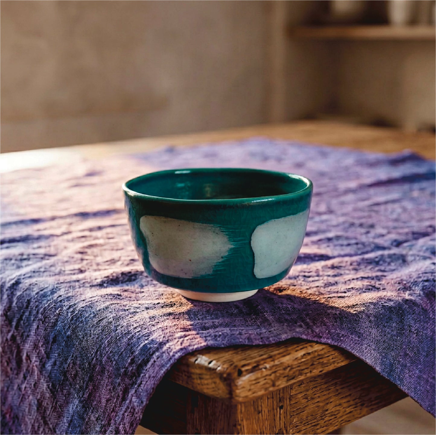 Handmade Japanese ceramic bowl on a textured purple cloth with a blurred background