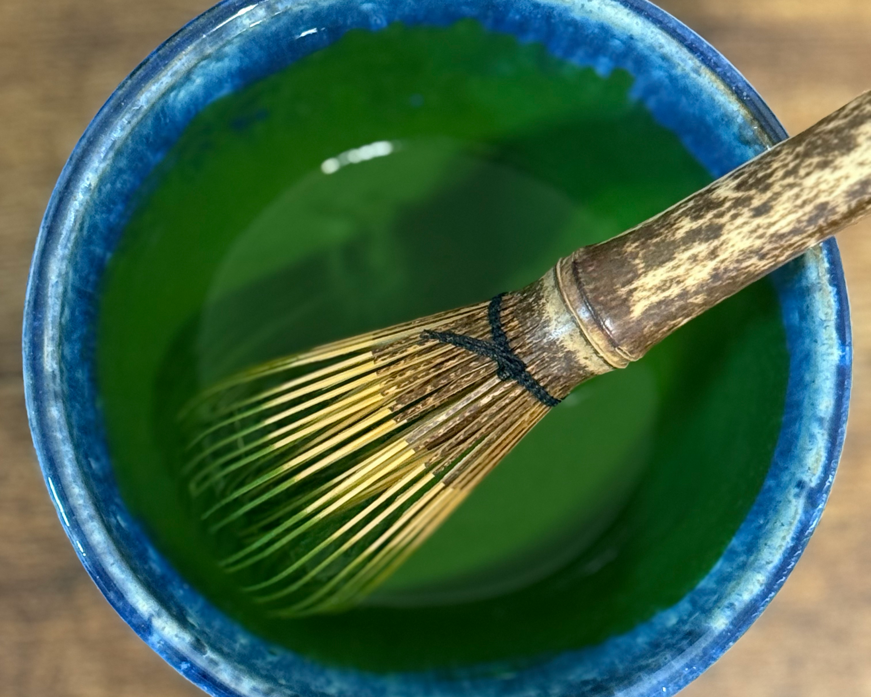 Traditional Japanese whisk (chasen) in a bowl of matcha