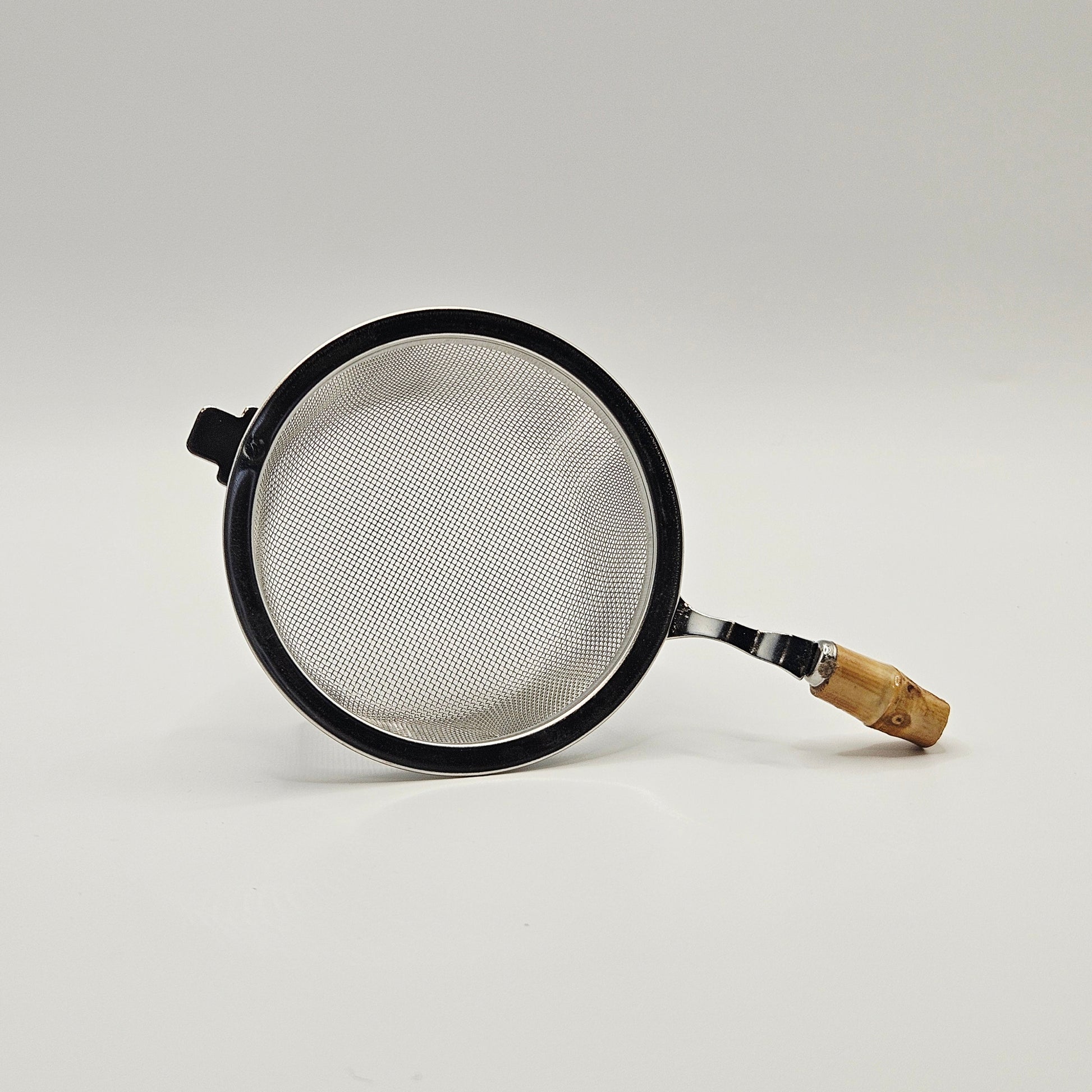 Metal strainer with wooden handle on a white background