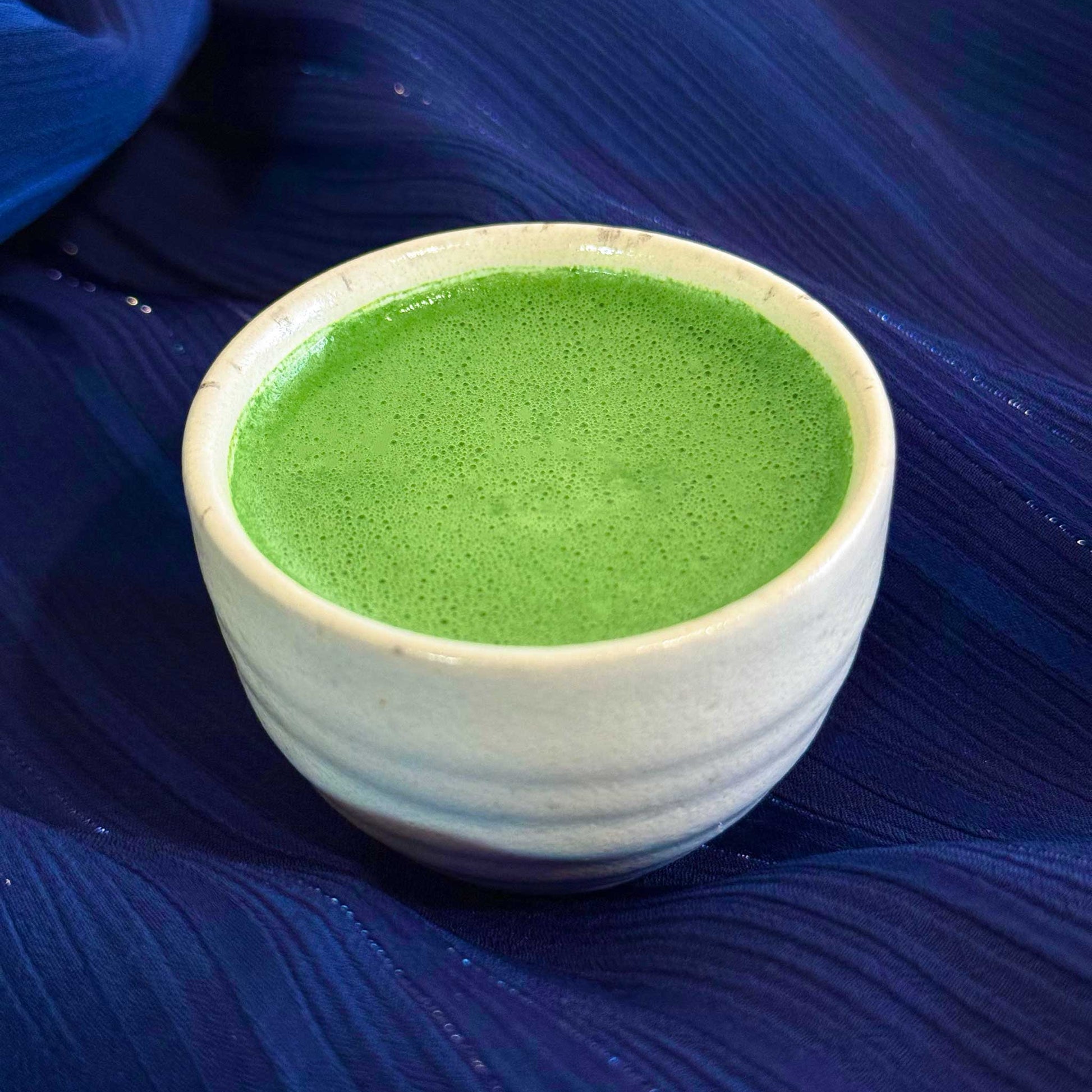 Nishi no Kawa Matcha prepared as usucha in a white cup on a blue background